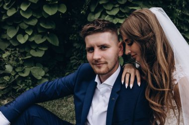 Güzel mutlu gelin ve damat düğün günü parkta poz veriyor.        