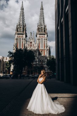 Gelinlikli gelin şehir caddesinde poz veriyor.