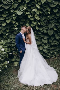 Güzel mutlu gelin ve damat düğün günü parkta poz veriyor.        