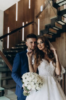 Güzel, genç, aşık bir çift lüks bir iç mekanda poz veriyor.        