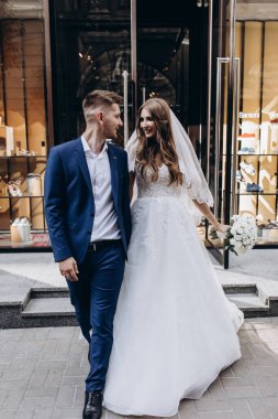 Mutlu evlilik çifti şehirde birlikte poz veriyor.                 