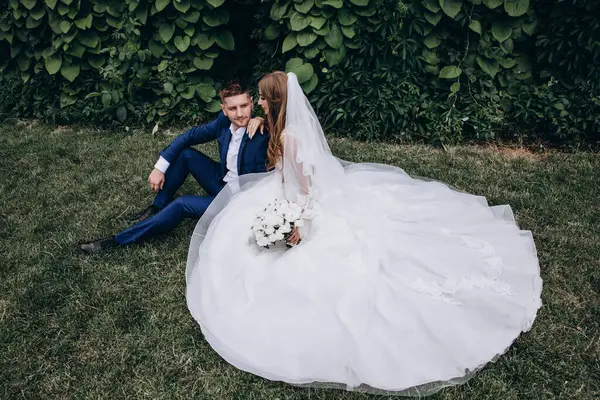 Güzel mutlu gelin ve damat düğün günü parkta poz veriyor.        