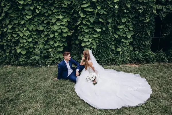 Güzel mutlu gelin ve damat düğün günü parkta poz veriyor.        