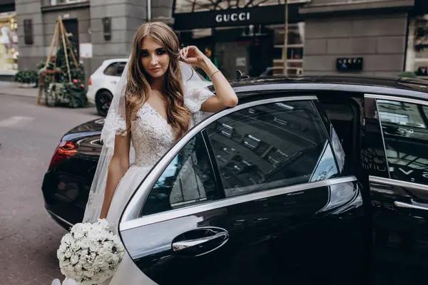 Bir buket çiçekli güzel gelin lüks bir arabayla geliyor.         