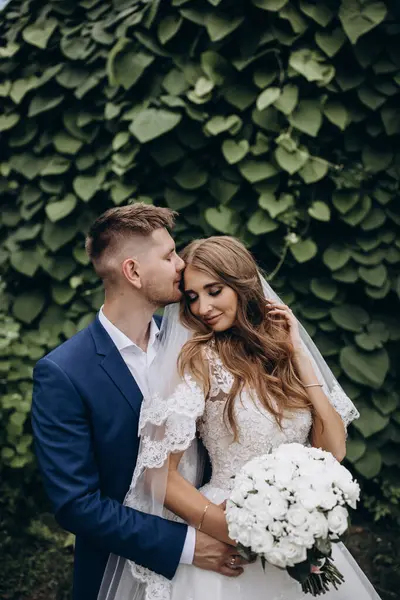 Güzel mutlu gelin ve damat düğün günü parkta poz veriyor.        