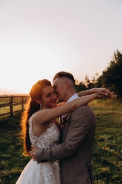 Gün batımında dışarıda poz veren mutlu genç bir çift.       