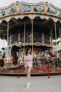 Lunaparkta atlı karıncayla poz veren güzel bir kadın.