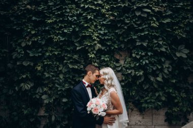 Genç ve güzel bir çiftin parkta kucaklaşmasının yan görüntüsü.  