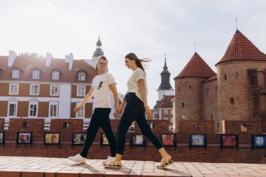 Güzel, genç aşık bir çift şehir sokaklarında yürüyor.                