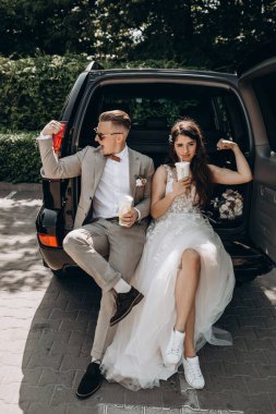 Güzel bir çift yeni evli arabada poz veriyor. Kokain içiyor, eğleniyor. Gelin ise bisepslerini damada gösteriyor. 