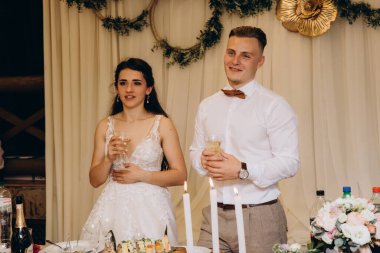 Lokantada dikilen mutlu evlilik çifti, neşeyle kadeh kaldırıyorlar..