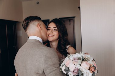 Genç bir çift öpüşüyor, düğün günlerinde poz veriyorlar. 