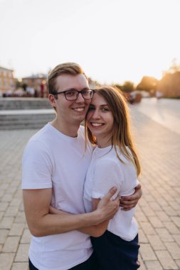 Genç bir çift, akşam saatlerinde sarılıyor.