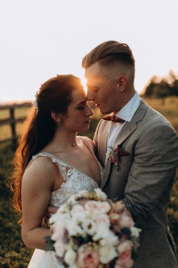 Gün batımında dışarıda poz veren mutlu genç bir çift.       