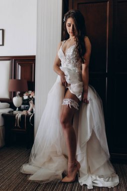 Gelinlikli güzel gelinin portresi odada poz veriyor. 