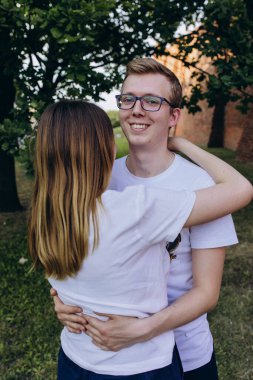 Genç ve aşık bir çift şehirde sarılıyor.