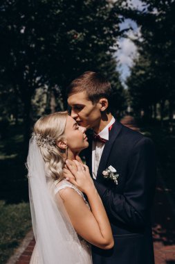 Genç ve güzel bir çiftin parkta kucaklaşmasının yan görüntüsü.  