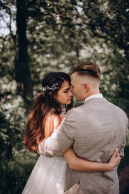 Güzel gelin ve damat düğün günü parkta kucaklaşıyorlar..   