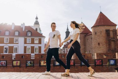 Güzel, genç aşık bir çift şehir sokaklarında yürüyor.                