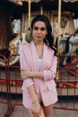 Lunaparkta atlı karıncayla poz veren güzel bir kadın.