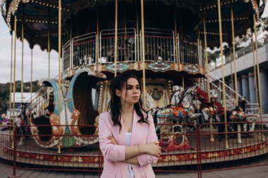 Lunaparkta atlı karıncayla poz veren güzel bir kadın.