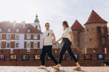 Güzel, genç aşık bir çift şehir sokaklarında yürüyor.                