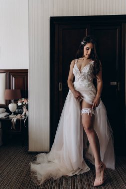 Gelinlikli güzel gelinin portresi odada poz veriyor.