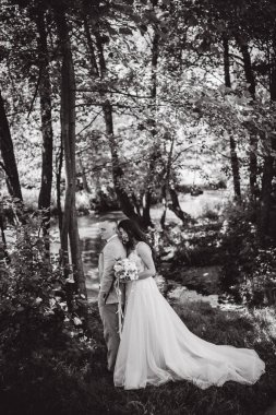 Güzel gelin ve damat düğün günü parkta kucaklaşıyorlar..   