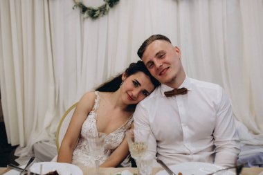 Lokantadaki masada oturan mutlu bir çift. Düğün günlerini kutluyorlar 