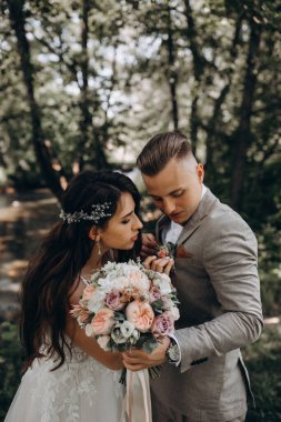 Düğün gününde dışarıda poz veren genç bir çift.