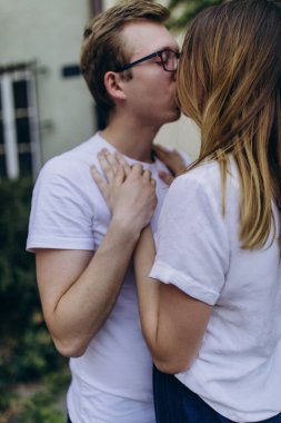 Açık havada beyaz tişört giyen mutlu bir çiftin portresi.