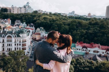 Güzel bir çift şehrin arka planında birbirine sarılıyor.