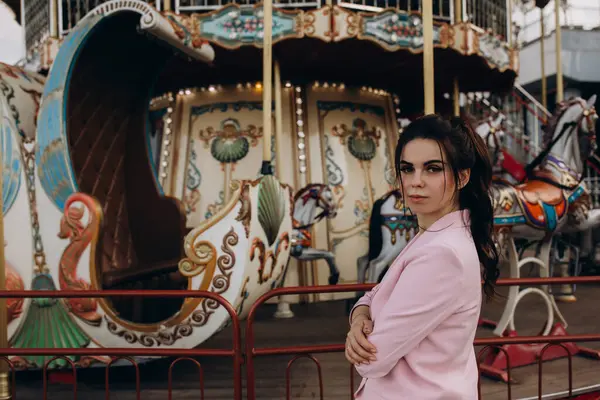 Lunaparkta atlı karıncayla poz veren güzel bir kadın.