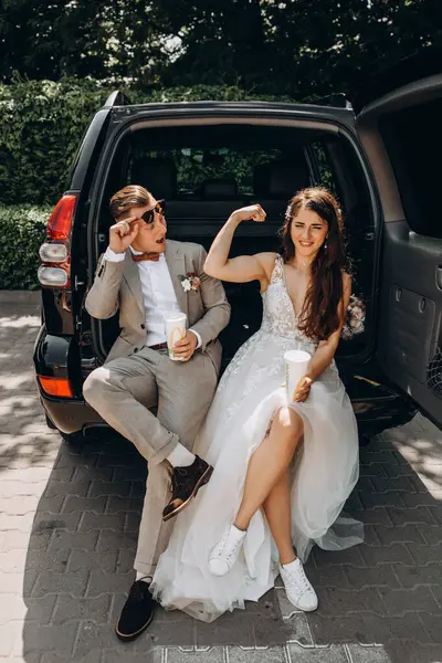 Güzel bir çift yeni evli arabada poz veriyor. Kokain içiyor, eğleniyor. Gelin ise bisepslerini damada gösteriyor.