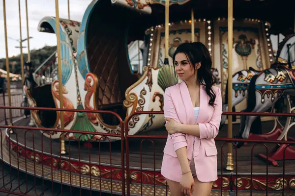 Lunaparkta atlı karıncayla poz veren güzel bir kadın.