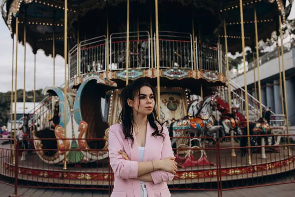 Lunaparkta atlı karıncayla poz veren güzel bir kadın.