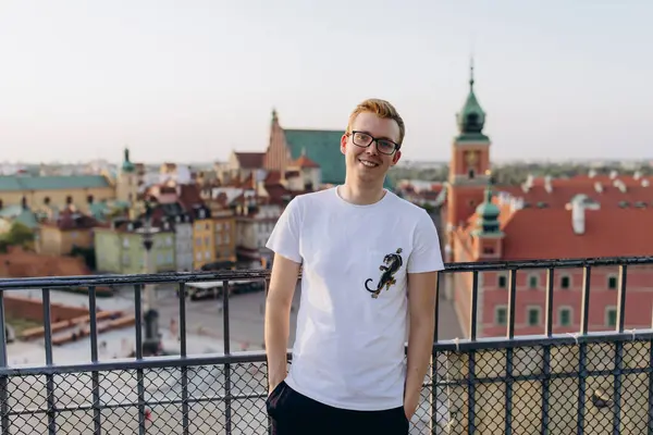 Genç yakışıklı adam eski şehirde çatıda poz veriyor. 