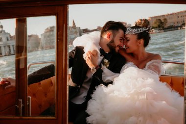 Mutlu gelin ve damat Venedik 'te teknede sarılıyor.