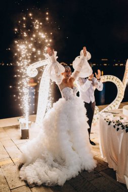 Genç ve güzel bir düğün çifti tezahürat yapıyor ve geceleri düğünü kutluyor.