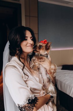 Güzel, genç bir gelin ve evde küçük sevimli bir köpek var.       