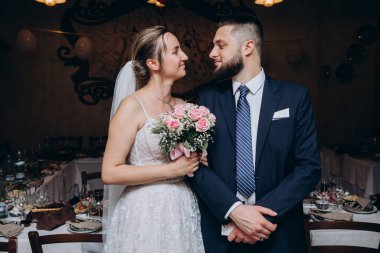 Gelin ve düğün buketi ve damat restoranda.