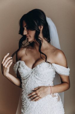 Beyaz gelinlik içindeki güzel gelinin portresi.              