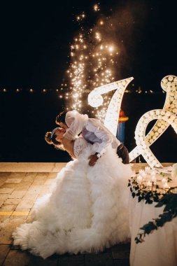 Güzel gelin ve damat akşam dans edip öpüşüyor. 