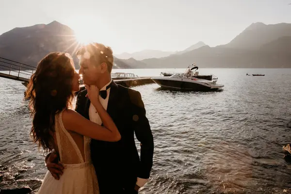 Güzel yeni evliler deniz kenarında gün batımında poz veriyorlar. 