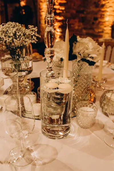 Mumlar ve çiçeklerle dolu güzel bir düğün masası. 