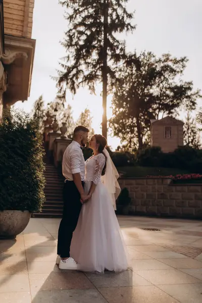 Düğün çifti şehirde dolanıyor ve gün batımında öpüşüyor.