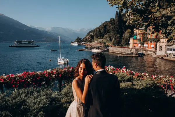 Gelin ve damat dağ gölü yakınlarında birlikte poz veriyorlar.