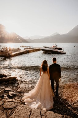 Güzel yeni evliler deniz kenarında gün batımında poz veriyorlar. 