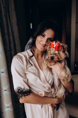 Güzel, genç bir gelin ve evde küçük sevimli bir köpek var.       