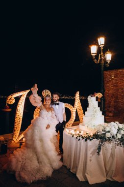 Mutlu gelin ve damat gece düğün pastasının yanında